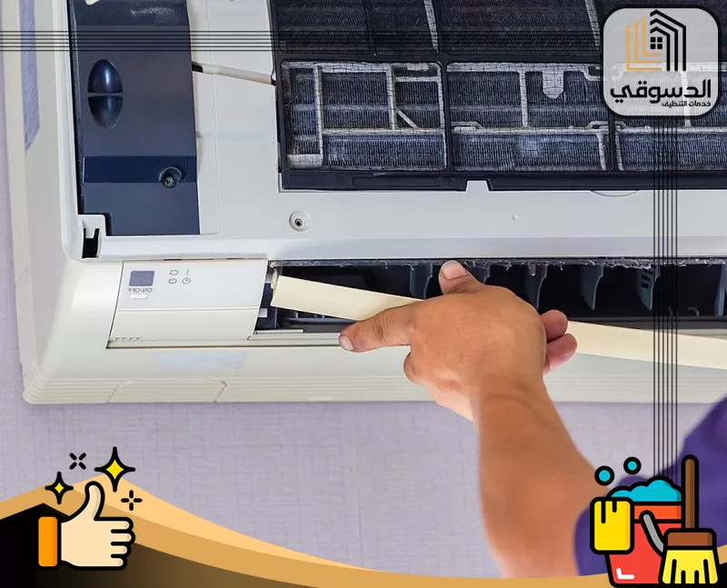 صيانة مكيفات سبليت عجمان 0545473541 الدسوقي فني تكييف يقوم بتنظيف فلتر المكيف الداخلي باستخدام أداة لفصل الأوساخ والغبار لضمان تدفق هواء نظيف.