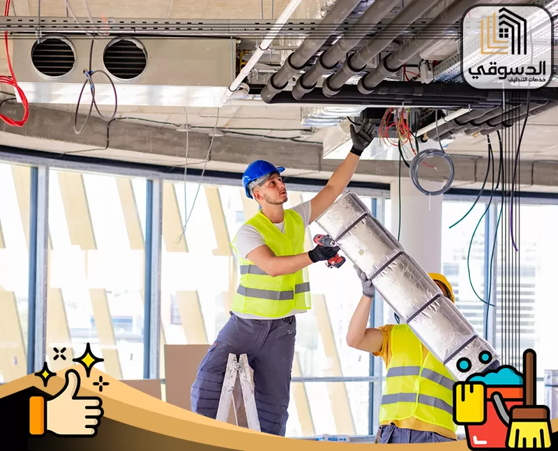 اصلاح مكيفات في الفجيرة 0545473541 الدسوقي فنيان يقومان بتركيب مجاري الهواء لمكيفات في السقف باستخدام الأدوات والمعدات اللازمة في موقع العمل.