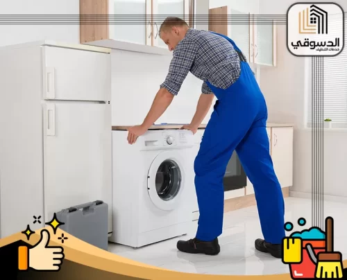 شركة تصليح غسالات مصفح ابوظبي 0545473541 الدسوقي فني يقوم بضبط الغسالة الأوتوماتيك داخل المطبخ لضمان تشغيل سليم