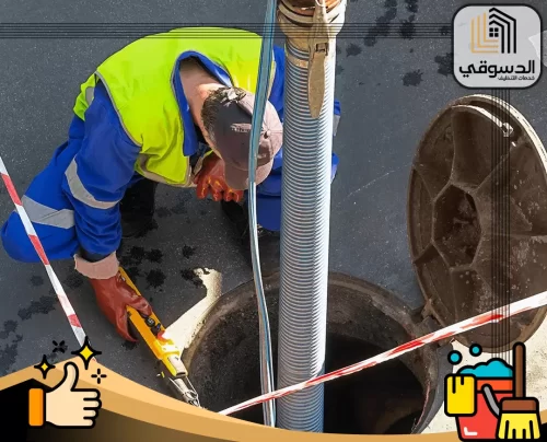 اسعار تسليك المجاري العين 0545473541 الدسوقي عامل صيانة يفحص غرفة تفتيش للصرف الصحي أثناء التنظيف