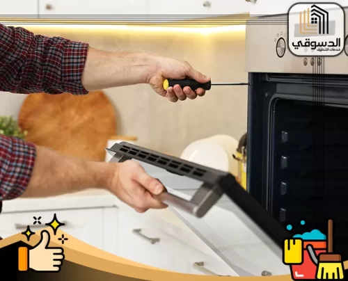 تصليح فرن في عجمان 0545473541 الدسوقي فني يفك باب فرن داخل مطبخ حديث باستخدام مفك بدقة