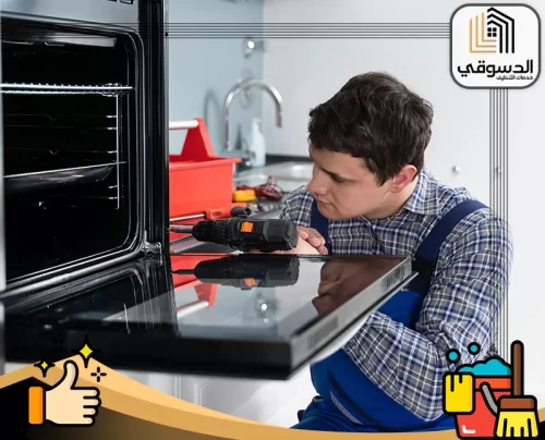 تصليح افران كهربائية في الفجيرة 0545473541 الدسوقي فني متخصص يفحص فرنًا مفتوحًا داخل المطبخ في أعمال صيانة دقيقة