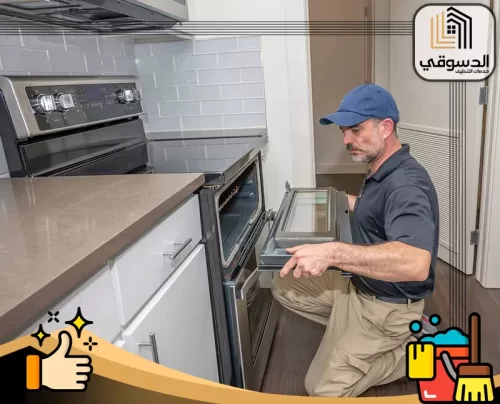 صيانة افران في راس الخيمة 0545473541 الدسوقي فني يفحص باب الفرن داخل المطبخ ضمن خدمة صيانة أفران منزلية