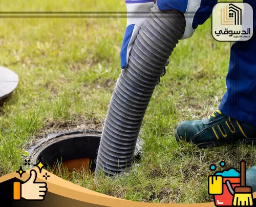 اسعار شركة تسليك مجاري ام القيوين 0545473541 الدسوقي خرطوم شفط كبير يدخل إلى غرفة صرف مفتوحة وسط العشب.